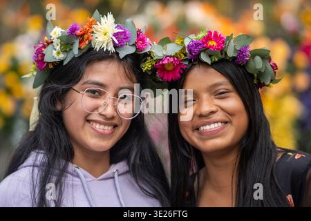 Festival de Flores - Antigua Guatemala - deux jeunes femmes sourient ensemble portant des couronnes florales vibrantes dans un cadre de festival en plein air, capturant un ami Banque D'Images