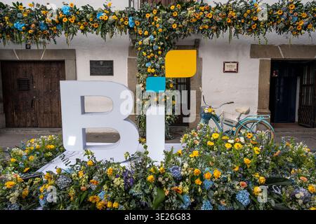 Festival de Flores - Antigua Guatemala - Un spectacle floral vibrant avec des fleurs jaunes et bleues, un vélo turquoise vintage et un blanc surdimensionné Banque D'Images