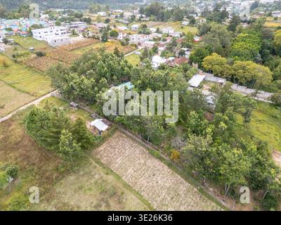 Aguacatan, Guatemala - vue aérienne d'un village rural et de petites fermes nichées au milieu d'arbres et de champs denses, avec des maisons dispersées, des chemins de terre et de l'agriculture Banque D'Images
