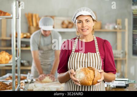 Femme adulte boulanger avec du pain fait maison Banque D'Images