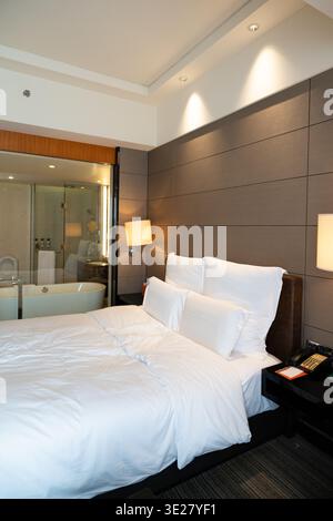 Chambre d'hôtel moderne avec lit King Size et vue sur la baignoire à Singapour Banque D'Images