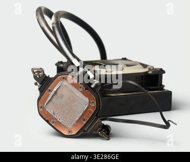 utilisé refroidisseur de cpu liquide poussiéreux fond gris clair isolé, plaque de base en cuivre avec vieille pâte thermique et tubes de radiateur, vue latérale avec mise au point douce Banque D'Images
