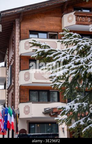 Façade alpine de l'hôtel de Zermatt avec drapeaux et balcons de chalet dans la neige Banque D'Images