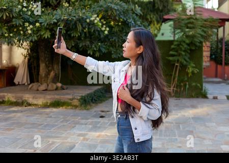 Heureux touriste prenant des photos avec smartphone à l'extérieur Banque D'Images