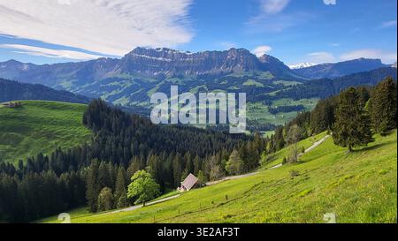 Panorama montagneux pittoresque de la chaîne de Schrattenfluh dans la région de l'Emmental en Suisse, avec des prairies verdoyantes et des forêts denses et luxuriantes Banque D'Images