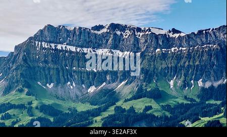 Panorama montagneux pittoresque de la chaîne de Schrattenfluh dans la région de l'Emmental en Suisse, avec des prairies verdoyantes et des forêts denses et luxuriantes Banque D'Images