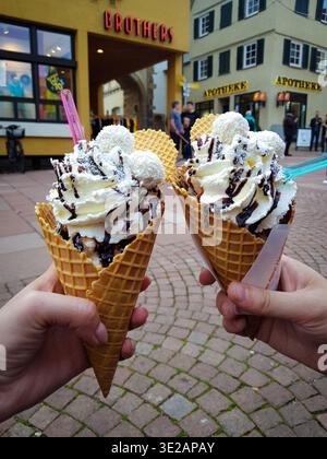 Deux gros cônes de crème glacée avec crème fouettée et sauce au chocolat Banque D'Images