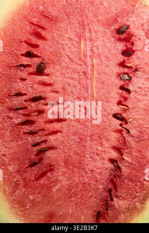 pulpe de pastèque rouge mûre avec des graines noires, une texture fibreuse naturelle et une chair juteuse dans un cadre plein, des fonds alimentaires sains Banque D'Images
