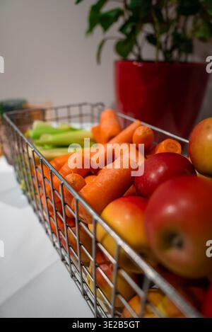 Panier en fil de métal avec carottes, pommes et céleri à Oberlech, Autriche Banque D'Images