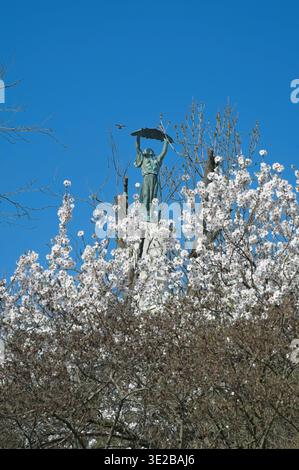 BUDAPEST, HONGRIE - 15 MARS 2026 : Statue de la liberté sur la colline Gellert vue à travers des amandiers en fleurs pendant la fête nationale du 15 mars Banque D'Images