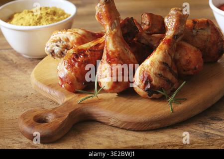 Cuisses de poulet grillé sur une planche à découper.fond dîner rustique Banque D'Images