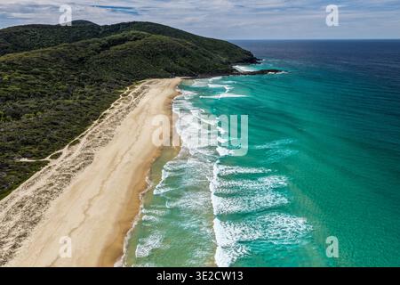 Vue aérienne par drone de Seven Mile Beach à Forster montrant une longue étendue de rivage sablonneux avec des vagues océaniques et des terres côtières naturelles environnantes Banque D'Images