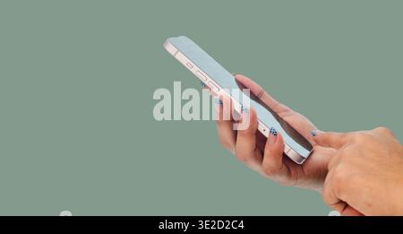 Main féminine tenant et tactile écran de smartphone sur fond vert, technologie et concept de navigation sans fil Banque D'Images