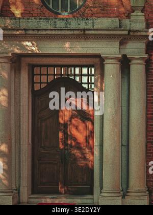 Une photographie en gros plan dramatique montrant une grande porte en bois brun foncé dans une structure architecturale classique à Hong Kong. L'image capture t Banque D'Images