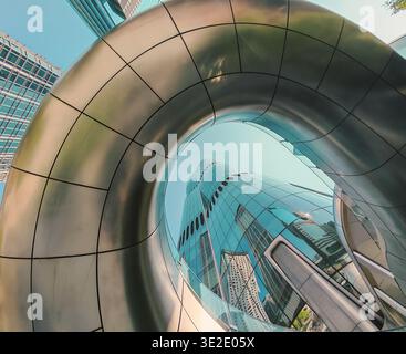 18 mars 2026 - Hong Kong : une vue imprenable en bas angle d'un bâtiment moderne dans le quartier des affaires de Hong Kong, avec un grand tunnel métallique incurvé Wit Banque D'Images