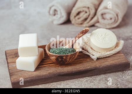 Divers savons, sels de bain et accessoires de bain sur fond bois et gris Banque D'Images