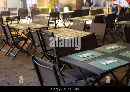 Tables et chaises de restaurant en plein air dans une cour Banque D'Images