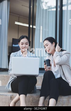 Deux femmes d'affaires ont une réunion productive au bureau. Ils discutent de questions commerciales, signent un contrat et se serrent la main Banque D'Images