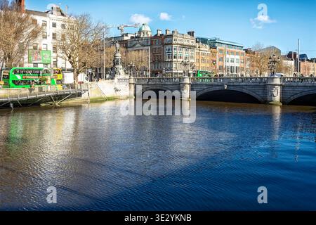 O'Connell Bridge et la rivière Liffey dans le centre-ville de Dublin avec une traversée traditionnelle de Dublin par bus par une journée ensoleillée. Banque D'Images