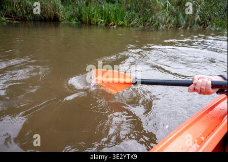 Gros plan de la main féminine en kayak paddle dans la rivière, concept de kayak, sport nautique, activité de plein air et aventure estivale Banque D'Images