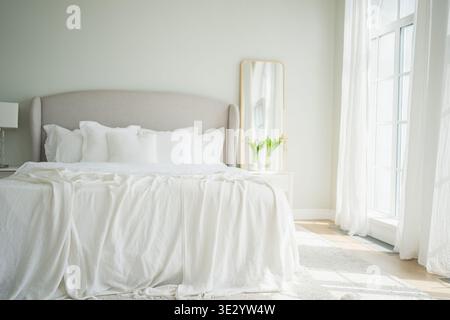Intérieur élégant de la chambre en mezzanine. Appartement spacieux design avec murs clairs grandes fenêtres grand lit. Décoration moderne et propre, mobilier élégant, style scandinave minimaliste Banque D'Images