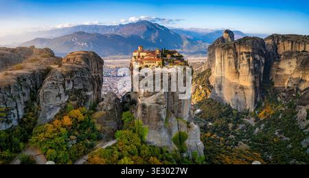 Vue panoramique aérienne du lever du soleil sur les montagnes des Météores avec le monastère d'Agia Triada situé sur une falaise haute au-dessus de la vallée, Grèce Banque D'Images