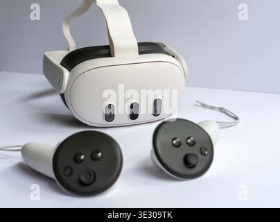 Casque de réalité virtuelle moderne avec deux contrôleurs sur la surface blanche, concept de jeu VR immersif et technologie numérique avancée Banque D'Images