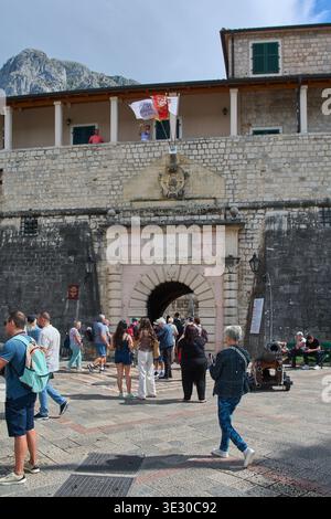 Kotor. Monténégro - 20 mars 2026 : les touristes se rassemblent à l'entrée de la porte de la mer de la vieille ville médiévale avec l'écusson du lion ailé vénitien et le histo Banque D'Images