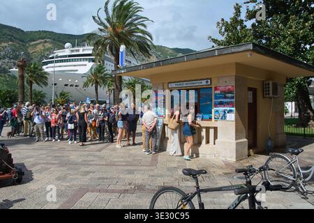 Kotor. Monténégro - 20 mars 2026 : grand groupe de passagers de bateaux de croisière rassemblés par le bureau d'information touristique au port avec une ligne de luxe Banque D'Images
