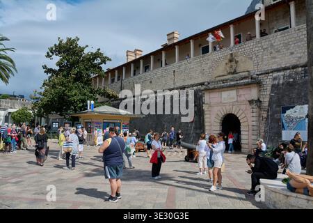 Kotor. Monténégro - 20 mars 2026 : les touristes se rassemblent à l'entrée de la porte de la mer des fortifications médiévales de la vieille ville avec des canons historiques et un touri Banque D'Images