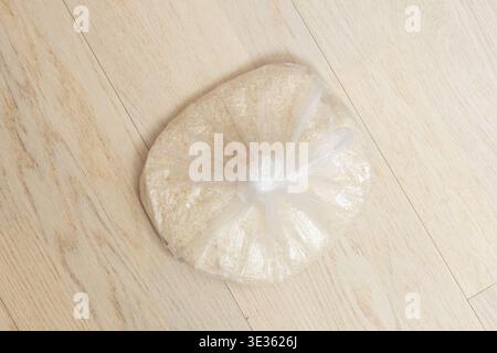 Cette prise de vue à grand angle comporte un sac en plastique transparent contenant une quantité importante de riz blanc non cuit à grain long. Le sac est solidement attaché w Banque D'Images