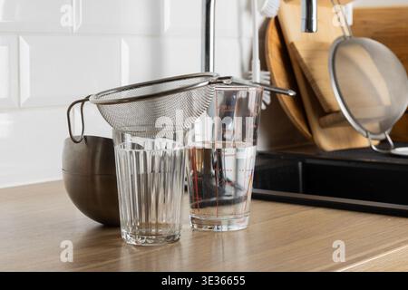Une scène de cuisine claire avec une passoire et des verres sur un comptoir Banque D'Images