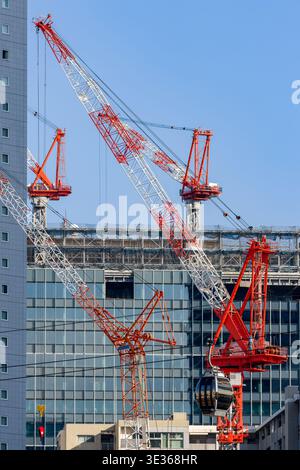 Développement urbain à Yokohama montrant de hautes grues de construction et le passage de la cabine de téléphérique Banque D'Images