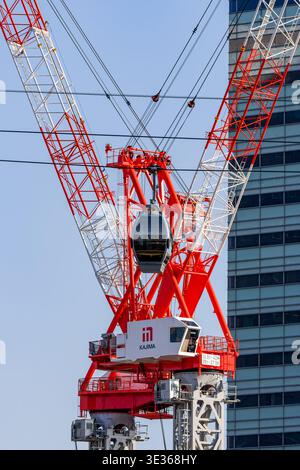 Téléphérique moderne passant devant une grue à tour et un gratte-ciel à Yokohama, au Japon Banque D'Images