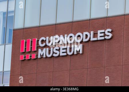 Gros plan de la signalisation du musée Cupnoodles sur l'architecture moderne en briques Banque D'Images