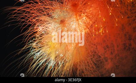 Feux d'artifice orange et jaune éclatant la nuit pendant la célébration de Moscou Banque D'Images