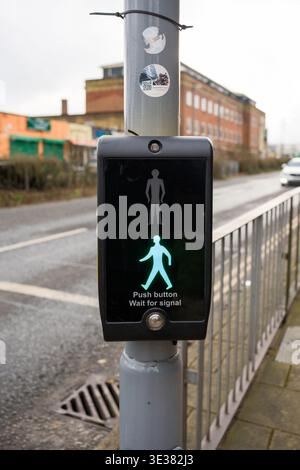 Une boîte de contrôle de passage piéton montrant l'homme vert signifiant prêt à traverser la route. Banque D'Images