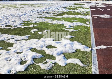 Neiges sur le terrain de football extérieur en basse saison de printemps Banque D'Images