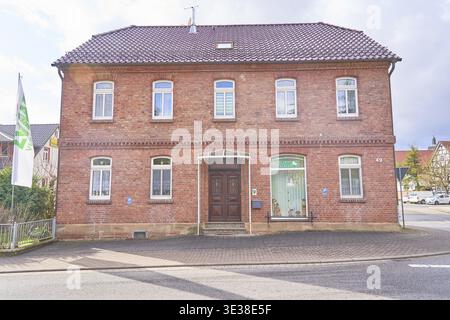 Bâtiment d'assurance LVM à Ershausen, Schimberg, Eichsfeld, Thuringe, Allemagne, une maison en brique avec des fenêtres distinctives dans un village sous ciel nuageux Banque D'Images