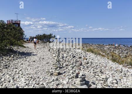 Champ de gravats, plage rocheuse, littoral avec sentier de randonnée sur l'île Stora Grundet, marcheur, pieu de pierre, phare de Langer Erik, Lange Erik, mer Baltique, ï¿½ Banque D'Images