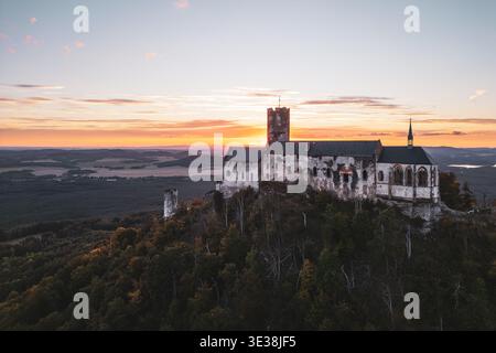 Magnifique vue aérienne du château de Bezdez perché sur une colline pendant le coucher du soleil. Les ruines médiévales mettent en valeur ses vieilles tours dans un contexte de cieux nocturne animé en été. Banque D'Images