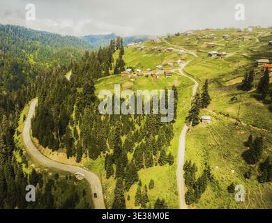 Vue aérienne voiture sur la route et vieilles maisons sur la colline dans le village de Bakhmaro en été. Lieu de villégiature touristique d'été célèbre dans les montagnes du caucase. Jour férié d Banque D'Images