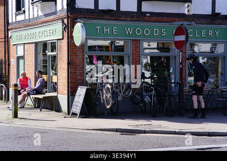 Le magasin de vélos Woods Cyclery avec des clients assis dehors un jour ensoleillé à Lyndhurst, New Forest, Hampshire, England.Lyndhurst, England Banque D'Images