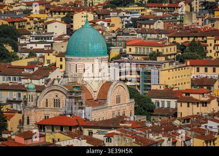 Grande synagogue avec un dôme en cuivre turquoise caractéristique et des éléments architecturaux mauresques au-dessus des toits en terre cuite dans la ville historique de Florence, en Italie Banque D'Images