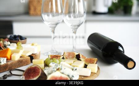 Plateau de fromage avec Une bouteille de vin sur Une table fait un plateau appétissant pour Une fête du vin Banque D'Images