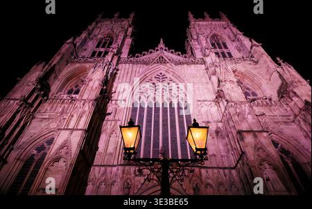 Deux lampadaires à l'ancienne Sine dans l'obscurité devant le grand West Front éclairé de la gothique York Minster, ville de York, Angleterre. Banque D'Images