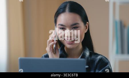 Sérieuse femme d'affaires coréenne asiatique freelance à la maison parlant téléphone mobile à l'aide d'un ordinateur portable appelant le support client appelez une fille professionnelle Banque D'Images