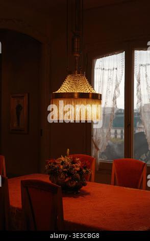 Lampe suspendue ornée à franges qui brille sur la table à manger à l'intérieur de la Casa Milà (la Pedrera), monument moderniste de Gaudí classé au patrimoine mondial de l'UNESCO, Barcelone, Espagne Banque D'Images