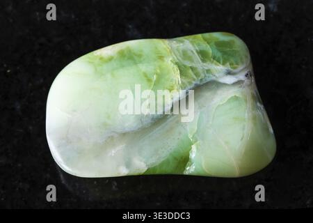 Échantillon de minéral opalite vert tondé sur fond de granit noir, gros plan d'Australie Banque D'Images