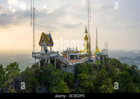 Temple de la grotte du tigre, Krabi/Thaïlande – 21 février 2020 : vue aérienne du complexe du temple perché avec une statue de Bouddha dorée et des tours de communication. Banque D'Images